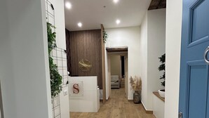 A modern hallway with wooden flooring, white walls, and a blue door. - Somnia Luxury Rooms  (Naples)