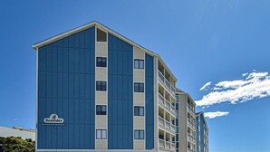 Ein mehrstöckiges Hotel mit blauer Fassade und einem Schild mit der Aufschrift "Seaside".