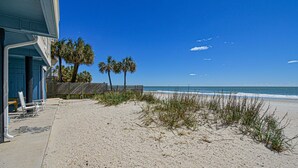Ein Strandgrundstück mit Sandstrand, Palmen und blauem Himmel.