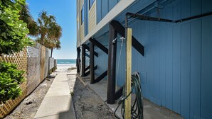 Ein Küstengebäude mit einem Betonweg, der zum Strand führt.