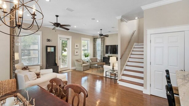 A spacious living area with a dining table, sofas, and a staircase leading to another level. - 2 Pools 1 heated, Private Beach Access, New Shops & Restaurants! NEW LISTING! (Santa Rosa Beach)
