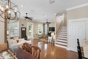 A spacious living area with a dining table, sofas, and a staircase leading to another level. - 2 Pools 1 heated, Private Beach Access, New Shops & Restaurants! NEW LISTING! (Santa Rosa Beach)