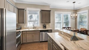 A modern kitchen with stainless steel appliances, a marble countertop, and a built-in dishwasher. - 2 Pools 1 heated, Private Beach Access, New Shops & Restaurants! NEW LISTING! (Santa Rosa Beach)