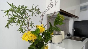 Una cocina moderna con encimera blanca, un tostador y un lavabo.