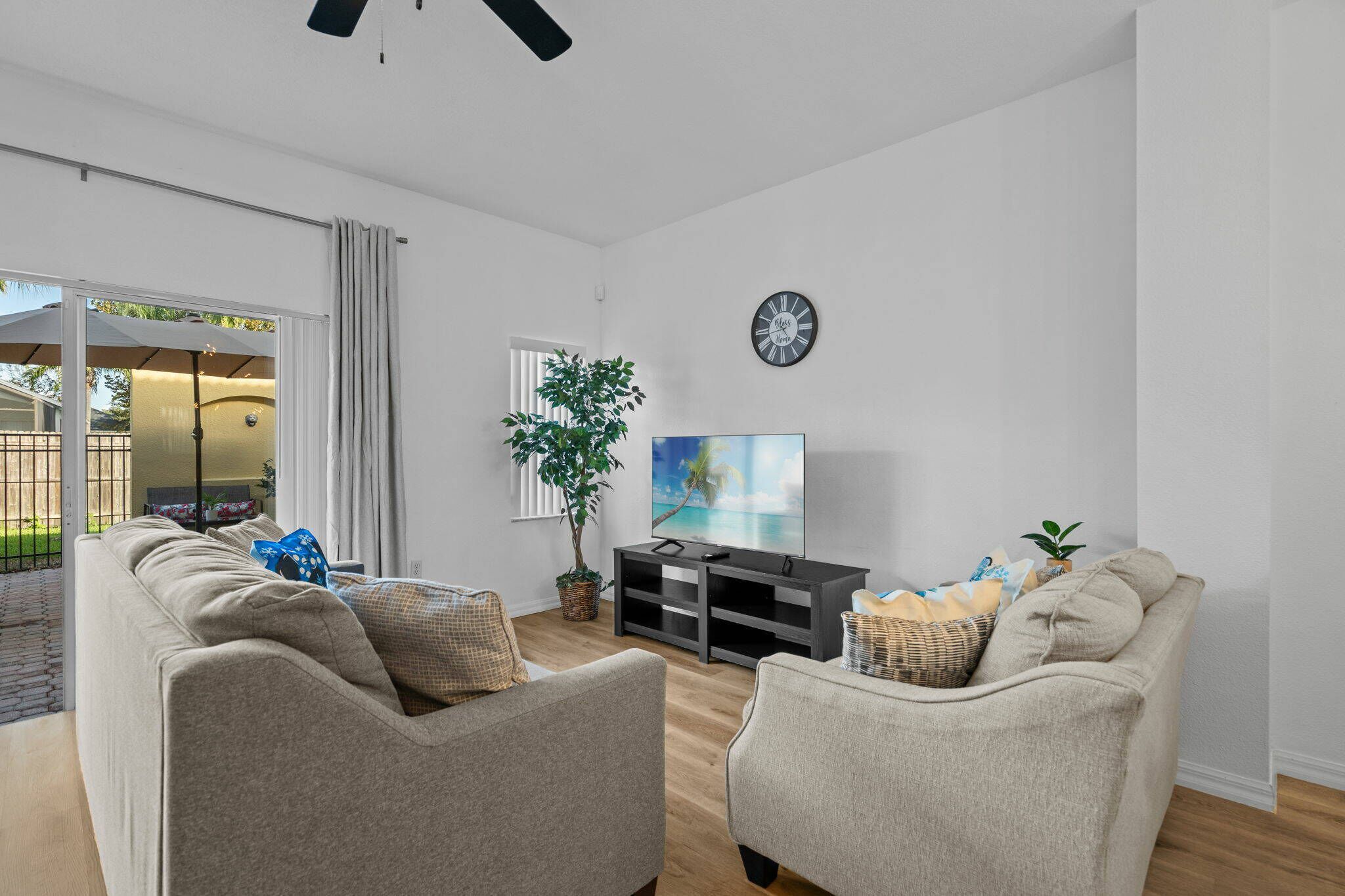 Ett modernt vardagsrum med en soffa, ett TV-bord och ett stort fönster.