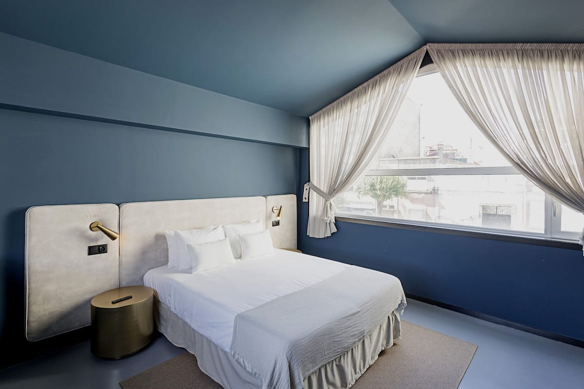 Un dormitorio moderno con una cama grande, una mesita de noche y una ventana con cortinas.