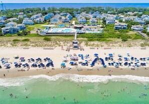 A coastal residential area with beachfront properties, a swimming pool complex, and a lifeguard tower. - Corolla Coastal Oasis 
Location, Amenities & Vibes (Currituck County)