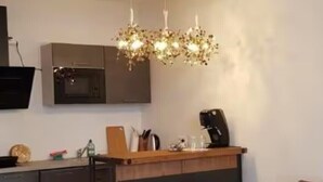 A modern kitchen with a bar area, a microwave, and a coffee machine.