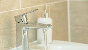 A modern bathroom with a chrome faucet and a soap dispenser. - Stylish 3-Bed Flat Near Cardiff City Centre & Uni (Cardiff)