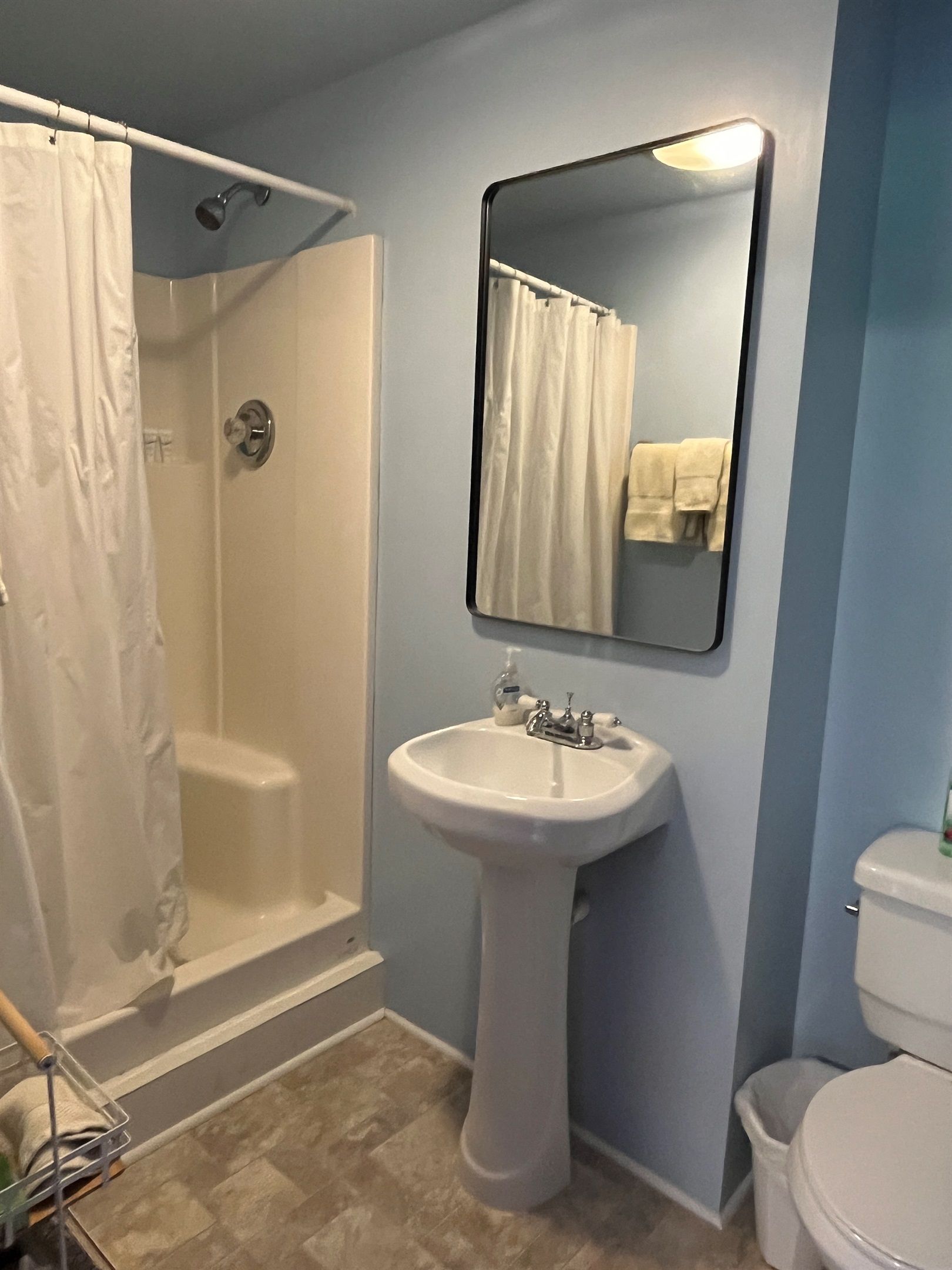 Une salle de bain équipée d’une douche, d’un lavabo, de toilettes et d’un miroir.