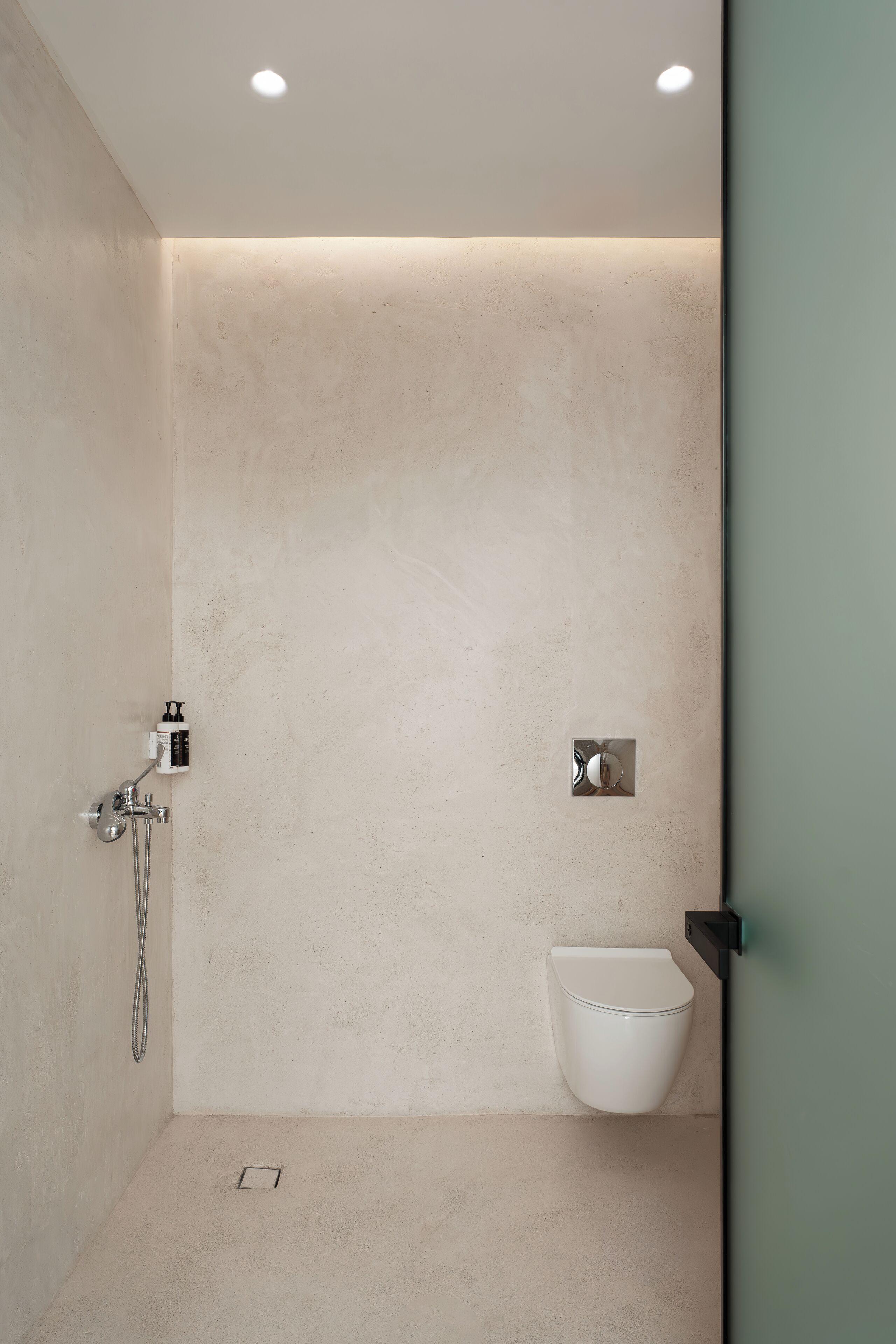 A modern bathroom with a shower, toilet, and a wall-mounted sink.