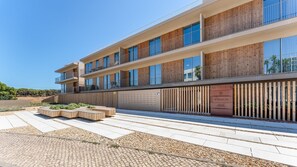 Ein modernes mehrgeschossiges Gebäude mit Holzverkleidung und großen Fenstern.