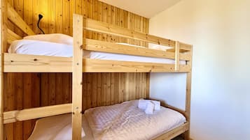 A bunk bed with wooden walls and a carpeted floor.