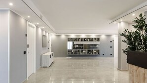 A modern hallway with a polished floor, white walls, and a built-in shelving unit with various items. - Villa Monterazzano by MMega (Viterbo)