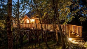 Eine Holzhütte mit einer Terrasse, umgeben von Bäumen.