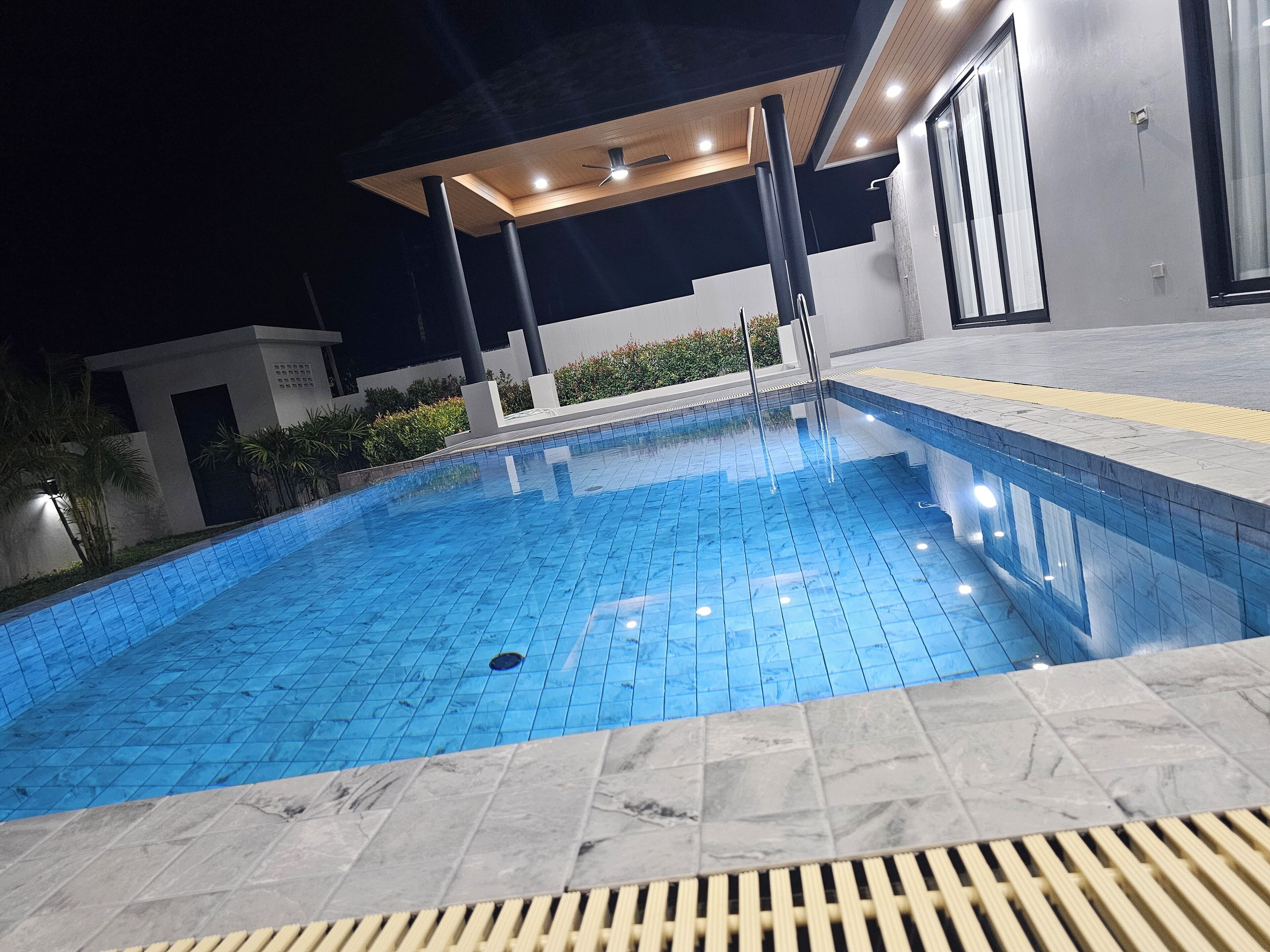 A swimming pool with a tiled edge and a drain in the center.