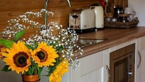 A kitchen with a wooden countertop, a sink, a toaster, and a book on a table. - Polgooth Garden B&B Pod 2 (Dog Friendly) (Saint Austell)