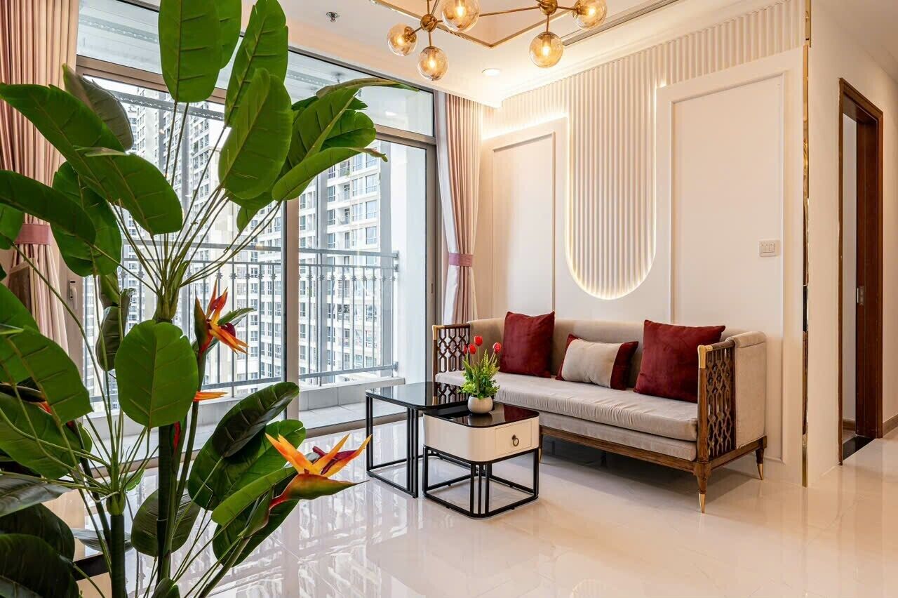 A modern living room with a sofa, a coffee table, and large windows offering a city view.