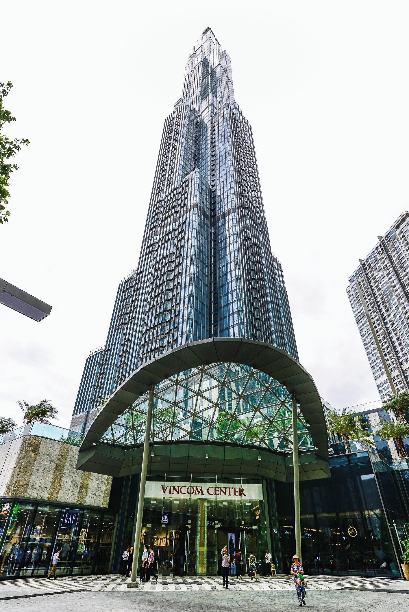 A modern building with a curved glass entrance labeled "VINCOM CENTER".
