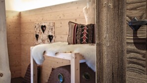 Een houten blokhut interieur met een bed, een hartvormige decoratie en een rustieke deur.