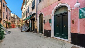 A narrow street with buildings, a covered area, and a sign indicating a business. - Apartment 'Casa Terrazza Marino' with Private Terrace and Wi-Fi (Levanto)