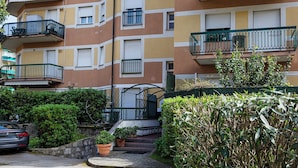 A multi-story residential building with balconies, a car parked in front, and potted plants. - Relax Apartment with Parking by Wonderful Italy (Santa Margherita Ligure)