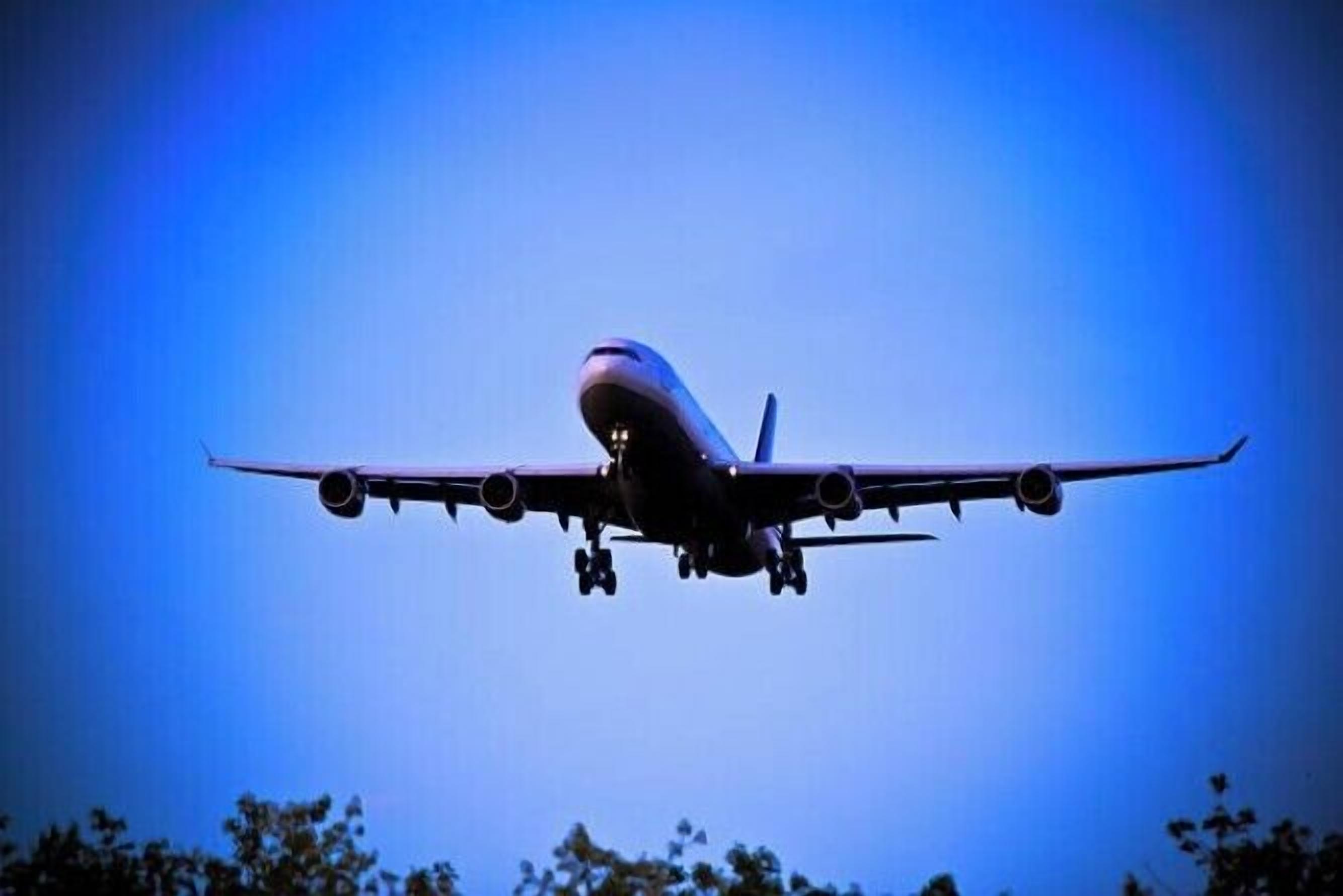 An airplane in flight against a clear blue sky.
