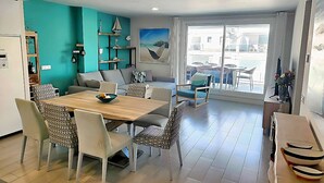 Un salon moderne comprenant un coin repas, un canapé, une table basse et une grande fenêtre offrant une vue dégagée.