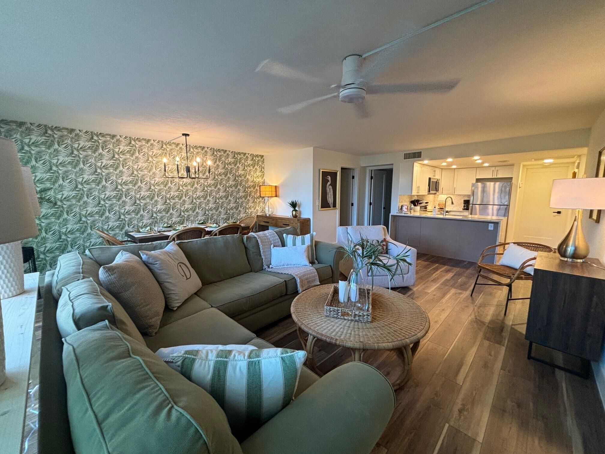 A modern living room with a sofa, a coffee table, and a dining area with chairs.
