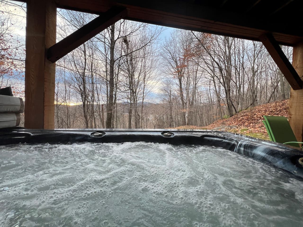 Ein Whirlpool mit Blick auf kahl stehende Bäume und einen klaren Himmel.