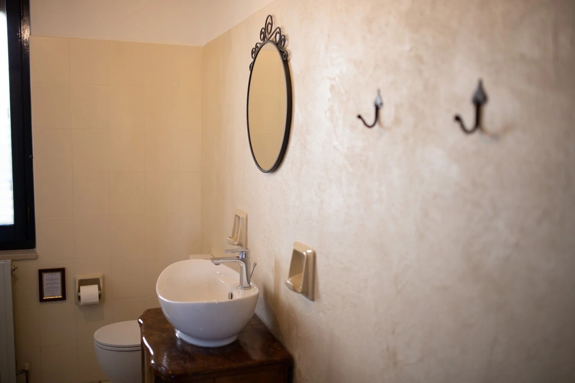 Ein Badezimmer mit einem weißen Waschbecken, einer Toilette und einem wandmontierten Spiegel.