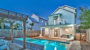 A two-story house with a swimming pool, outdoor seating, and a covered patio area. - King's Castle | Luxury Beach Escape | Huge Private Pool/Spa | 6-Seater Golf Cart (Destin)