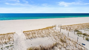 Ein Sandstrand mit blauem Himmel und dem Meer.