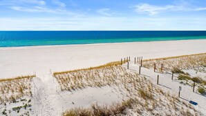 Une plage de sable fin, avec un ciel bleu clair et une mer azurée.
