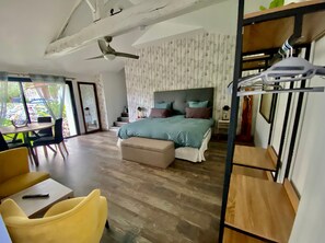 Une chambre à coucher avec un lit, un ventilateur de plafond, une fenêtre et une vue sur l’extérieur.