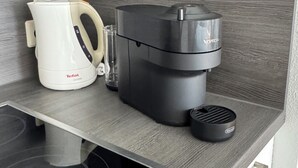 Une cuisine équipée d’une cuisinière moderne, d’une machine à café et d’un appareil à café.