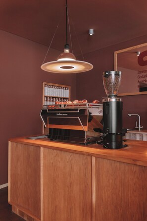 Ein Coffeeshop mit Kaffeemühle, Espressomaschine und einer Auswahl an Kaffeetassen.