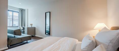 Een hotelkamer met een bed, een bureau, een stoel en een raam.