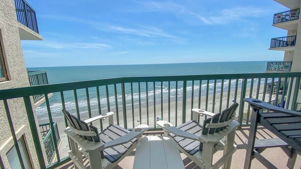 A balcony with a view of the ocean, two chairs, a table, and a railing. - 14th floor 4BR/3BA Ocean Front Condo: Stunning Views & Upgraded Ocean Bay Club (North Myrtle Beach)
