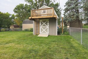 A small wooden shed with a wooden deck and a ladder leading up to a door. - Family Fun Oasis: Pool, Hot Tub, Arcade & Ninja Course with 4 Bedrooms! (Omaha)
