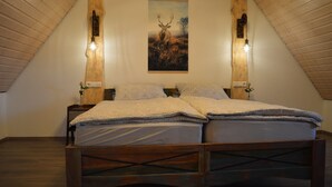 Ein Schlafzimmer mit einem hölzernen Bett, zwei Nachttischlampen und einem Hirschgemälde im Rahmen an der Wand.