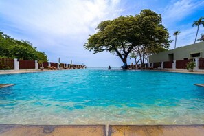 A clear blue pool with lounge chairs and a large tree in the center. - 2 Bedroom in Prime Location BSRS (Hua Hin)