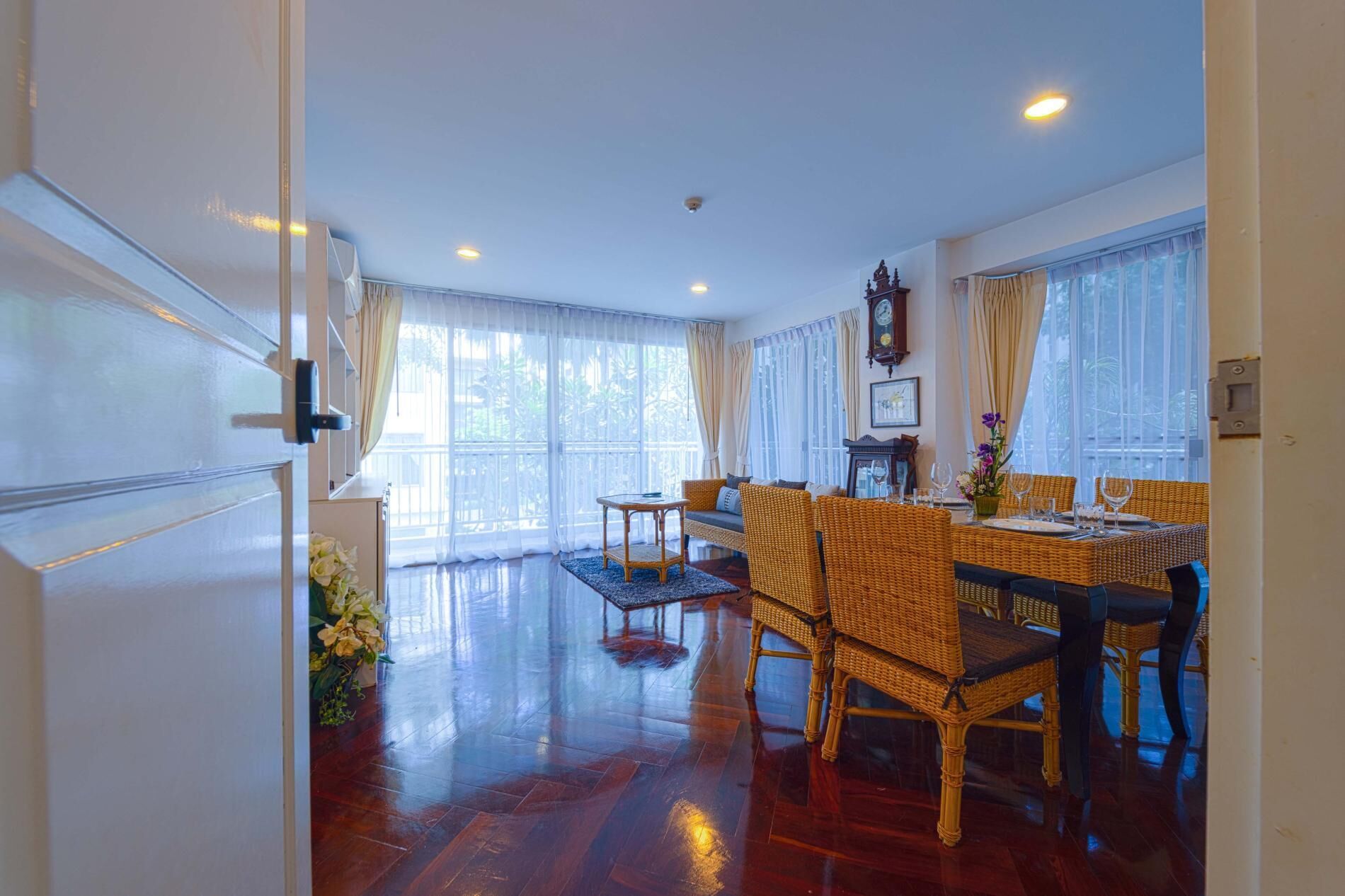 A spacious dining area with wicker furniture and a large window.