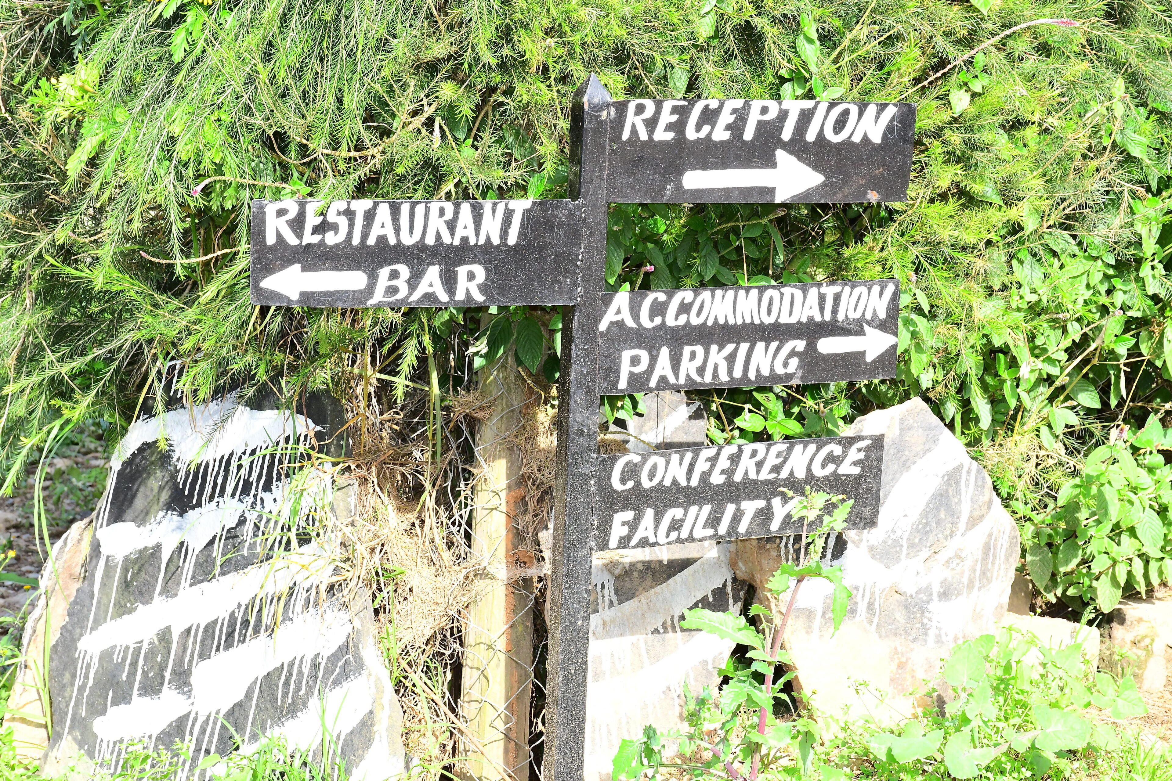 Panneaux de signalisation indiquant l’emplacement d’un restaurant-bar, d’un parking pour les clients de l’établissement et d’un centre de conférences.