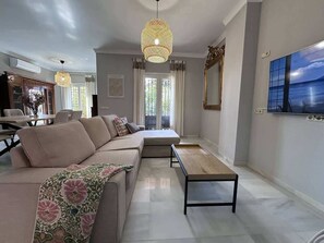A modern living room with a sofa, a coffee table, and a television. - Villa Brisa Beach with Grill & Pool Málaga (La Cala del Moral)