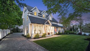 Une maison à deux étages avec une pelouse bien entretenue et une allée pavée.