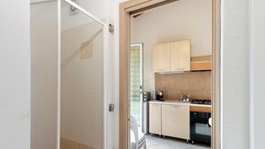 A kitchen with cabinets, a microwave, and a stove. - Apartment with Private Garden and Wi-Fi in Santo Stefano al Mare (Santo Stefano al Mare)