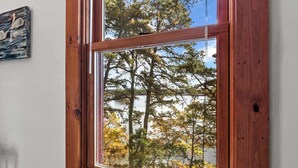 Ein Fenster mit Blick auf Bäume und ein Gebäude.
