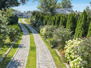 A stone pathway leading to a house with a well-maintained garden and a clear view of the property. - Pool, Hot Tub, Water Views and more! (Chatham)