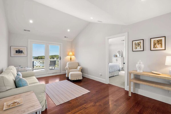 Un salón espacioso con un gran ventanal, un sofá acogedor, un sillón y una mesa de centro de madera.